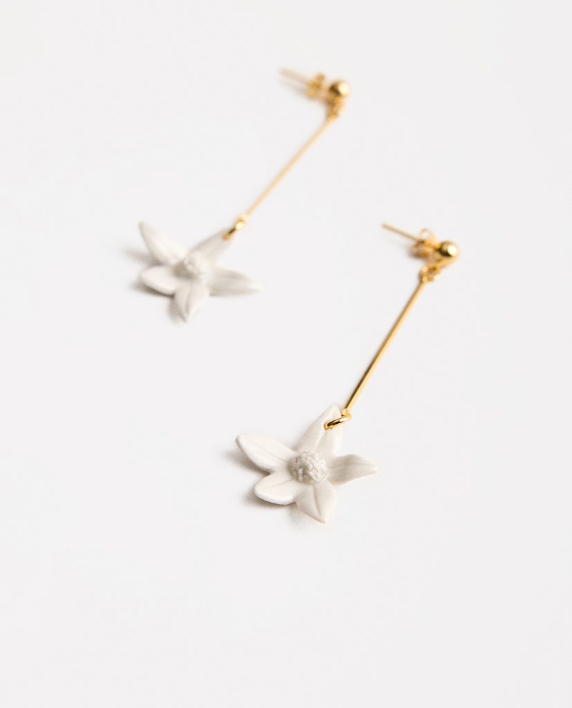 Pendientes largos flor de azahar.
&nbsp;Pendientes alargados rígidos de latón  bañado en oro,  flor de azahar de porcelana.Medidas largo de pendiente: 4,5 cm.Medidas flor 2,6cm.&nbsp;El proceso cerámico siempre es impredecible, mágico y único; cada complemento está dotado de singularidad. El texto irregular de este collar hace que cada uno de ellos sea una PIEZA ÚNICA.  Es por ello que pueden existir algunas leves modificaciones en la forma o el color de la fotografía en relación con la pieza que recibas en casa. Forma parte del juego saber que tendrás una pieza tuya e irrepetible, pues no hay ni habrá otra igual.