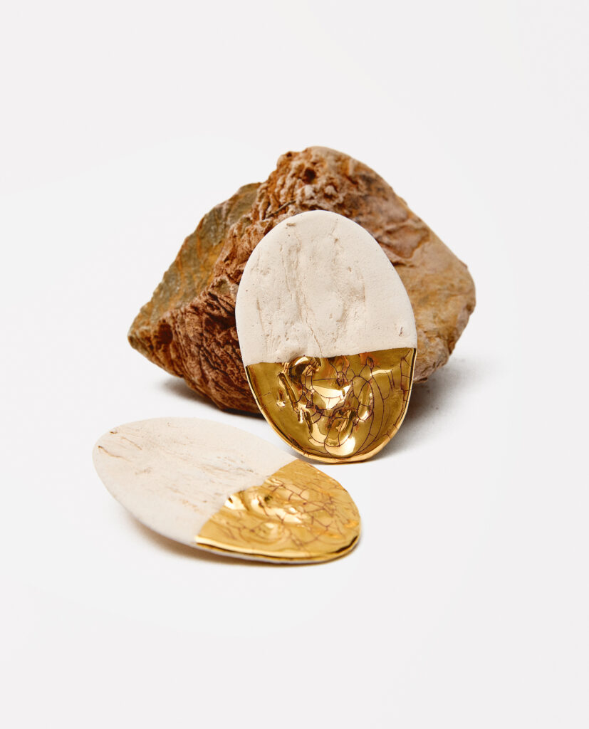 Colección TERRA.
- HARA nace del equilibrio: un punto donde la forma se calma y la tierra respira.Estos pendientes capturan la esencia de lo simple, lo honesto y lo esencial.HARA es un gesto de serenidad con mirada en el horizonte. 
&nbsp;Pendientes realizado en gres y cocido a 1220ºC. Lustrados en oro, modelados lisos o con textura de árbol.Tamaño aproximado 6 x 4 cm.&nbsp;
Piezas únicas de cerámica realizadas mediante un proceso artesanal
En La Polaca, cada creación nace de un cuidadoso proceso artesanal. Trabajamos la porcelana, gres y arcillas a mano, modelando, esmaltando, lustrando y dando forma a cada detalle con dedicación y sensibilidad. Cada pieza evoluciona de manera natural en el taller, siguiendo el ritmo del oficio cerámico.
El resultado es siempre una pieza única, con matices, texturas y pequeñas variaciones que le otorgan personalidad propia.