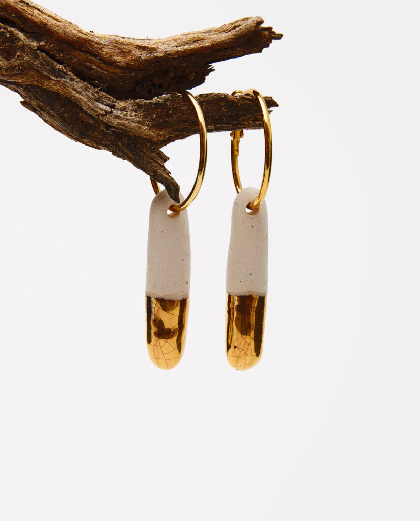 Colección TERRA.
- ELOA es el instante en que la luz toca la tierra y la transforma. Modelados en gres, cada pendiente guarda la huella mineral del origen; y sobre su superficie, el oro se posa como un susurro luminoso, un destello que revela lo sagrado en lo simple. ELOA nace del diálogo entre materia y brillo:la calma profunda del barro y la claridad que se eleva, suave, hacia lo etéreo. Son piezas que celebran lo que asciende sin prisa, lo que ilumina sin imponerse, lo que recuerda que la belleza también puede ser un murmullo
Pendientes  realizado en gres y cocido entre  1220ºC y 1260ºC . Lustrados en oro.Medidas de la pieza  cerámica  5 x 1,3 cm. Pieza metálica dorada en acero inoxidable.&nbsp;&nbsp;
Piezas únicas de cerámica realizadas mediante un proceso artesanal
En La Polaca, cada creación nace de un cuidadoso proceso artesanal. Trabajamos la porcelana, gres y arcillas a mano, modelando, esmaltando, lustrando y dando forma a cada detalle con dedicación y sensibilidad. Cada pieza evoluciona de manera natural en el taller, siguiendo el ritmo del oficio cerámico.
El resultado es siempre una pieza única, con matices, texturas y pequeñas variaciones que le otorgan personalidad propia.
&nbsp;&nbsp;&nbsp;