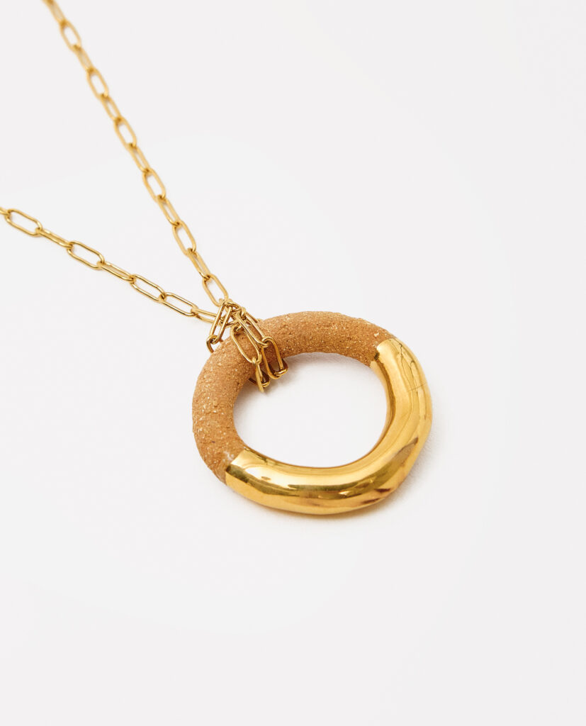 Colección TERRA.
- LUMA es luz capturada en cerámica. Pendientes que reflejan la suavidad de la arcilla y la calidez de lo hecho a mano. Cada curva y textura revela un juego sutil entre forma y movimiento, creando un accesorio que brilla con naturalidad. LUMA es un pequeño destello para llevar contigo.
&nbsp;Collar  realizado en gres y cocido a 1220ºC y 1260ºC. Lustrados en oro.Diámetros de cerámica de 3,3cm. Cadena de  acero.&nbsp;&nbsp;
Piezas únicas de cerámica realizadas mediante un proceso artesanal
En La Polaca, cada creación nace de un cuidadoso proceso artesanal. Trabajamos la porcelana, gres y arcillas a mano, modelando, esmaltando, lustrando y dando forma a cada detalle con dedicación y sensibilidad. Cada pieza evoluciona de manera natural en el taller, siguiendo el ritmo del oficio cerámico.
El resultado es siempre una pieza única, con matices, texturas y pequeñas variaciones que le otorgan personalidad propia.