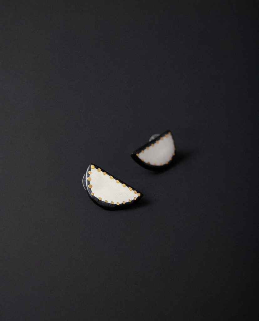 Colección CAREY.
- Cada luna partida guarda un destello dorado. Amuletos CAREY que susurran suerte y protección.
&nbsp;Pendientes realizado en cerámica blanca con forma de media luna, decorada con lustre de oro.Tamaño de la pieza cerámica: 1,3 x 2,5 cm (aproximado). Base de plata.&nbsp;&nbsp;&nbsp;
Piezas únicas de cerámica realizadas mediante un proceso artesanal
En La Polaca, cada creación nace de un cuidadoso proceso artesanal. Trabajamos la porcelana, gres y arcillas a mano, modelando, esmaltando, lustrando y dando forma a cada detalle con dedicación y sensibilidad. Cada pieza evoluciona de manera natural en el taller, siguiendo el ritmo del oficio cerámico.
El resultado es siempre una pieza única, con matices, texturas y pequeñas variaciones que le otorgan personalidad propia.