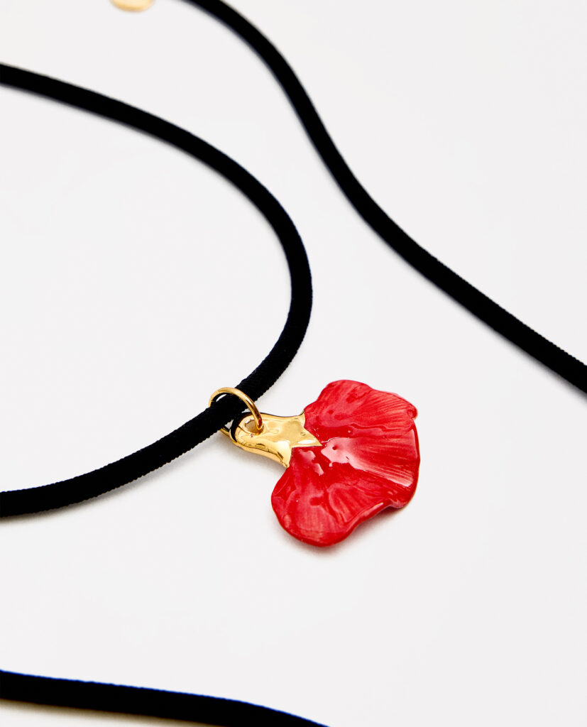 CLAVEL.
Collar elástico negro con terminaciones en acero dorado. Pieza clavel de cerámica modelada a mano, esmaltada y cocida a 1000 grados. Lustrada en oro.Medida pieza cerámica:  4 x 4 cm (medidas aproximadas).
Piezas únicas de cerámica realizadas mediante un proceso artesanal
En La Polaca, cada creación nace de un cuidadoso proceso artesanal. Trabajamos la porcelana, gres y arcillas a mano, modelando, esmaltando, lustrando y dando forma a cada detalle con dedicación y sensibilidad. Cada pieza evoluciona de manera natural en el taller, siguiendo el ritmo del oficio cerámico.
El resultado es siempre una pieza única, con matices, texturas y pequeñas variaciones que le otorgan personalidad propia.