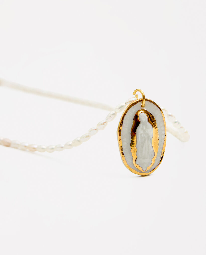 REGINA CAELI (Reina del cielo).
Collar medalla Virgen de Guadalupe, modelada y pintada a mano, realizada en PORCELANA, cocida a 1230 grados y lustrada en ORO.Collar de perla natural forma orgánica 5mm.Medidas de la medalla: 2 x 3 cm.Medidas longitud collar de perlas: 42cm.&nbsp;
Piezas únicas de cerámica realizadas mediante un proceso artesanal
En La Polaca, cada creación nace de un cuidadoso proceso artesanal. Trabajamos la porcelana, gres y arcillas a mano, modelando, esmaltando, lustrando y dando forma a cada detalle con dedicación y sensibilidad. Cada pieza evoluciona de manera natural en el taller, siguiendo el ritmo del oficio cerámico.
El resultado es siempre una pieza única, con matices, texturas y pequeñas variaciones que le otorgan personalidad propia.
