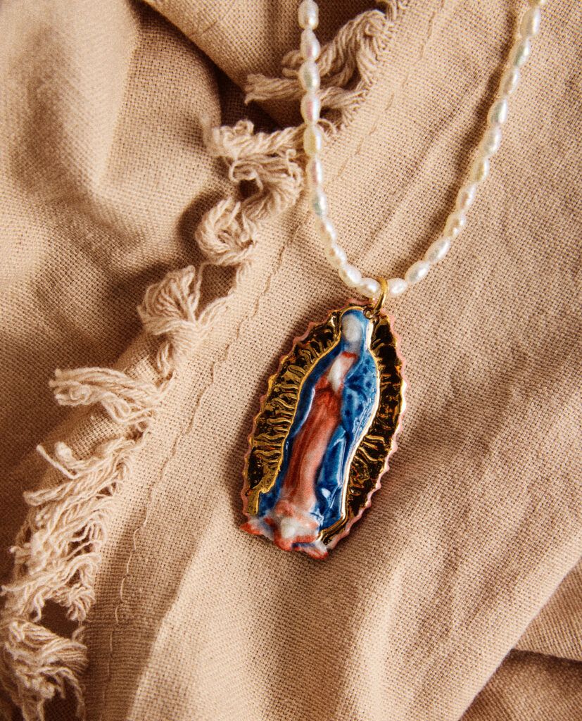 REGINA CAELI (Reina del cielo).
Collar medalla Virgen de Guadalupe, modelada y pintada a mano, realizada en PORCELANA, cocida a 1230 grados y lustrada en ORO.Collar de perla natural forma orgánica 5mm.Medidas de la medalla: 4,5 x 2,5 cm.Medidas longitud collar de perlas: 44cm.&nbsp;
Piezas únicas de cerámica realizadas mediante un proceso artesanal
En La Polaca, cada creación nace de un cuidadoso proceso artesanal. Trabajamos la porcelana, gres y arcillas a mano, modelando, esmaltando, lustrando y dando forma a cada detalle con dedicación y sensibilidad. Cada pieza evoluciona de manera natural en el taller, siguiendo el ritmo del oficio cerámico.
El resultado es siempre una pieza única, con matices, texturas y pequeñas variaciones que le otorgan personalidad propia.