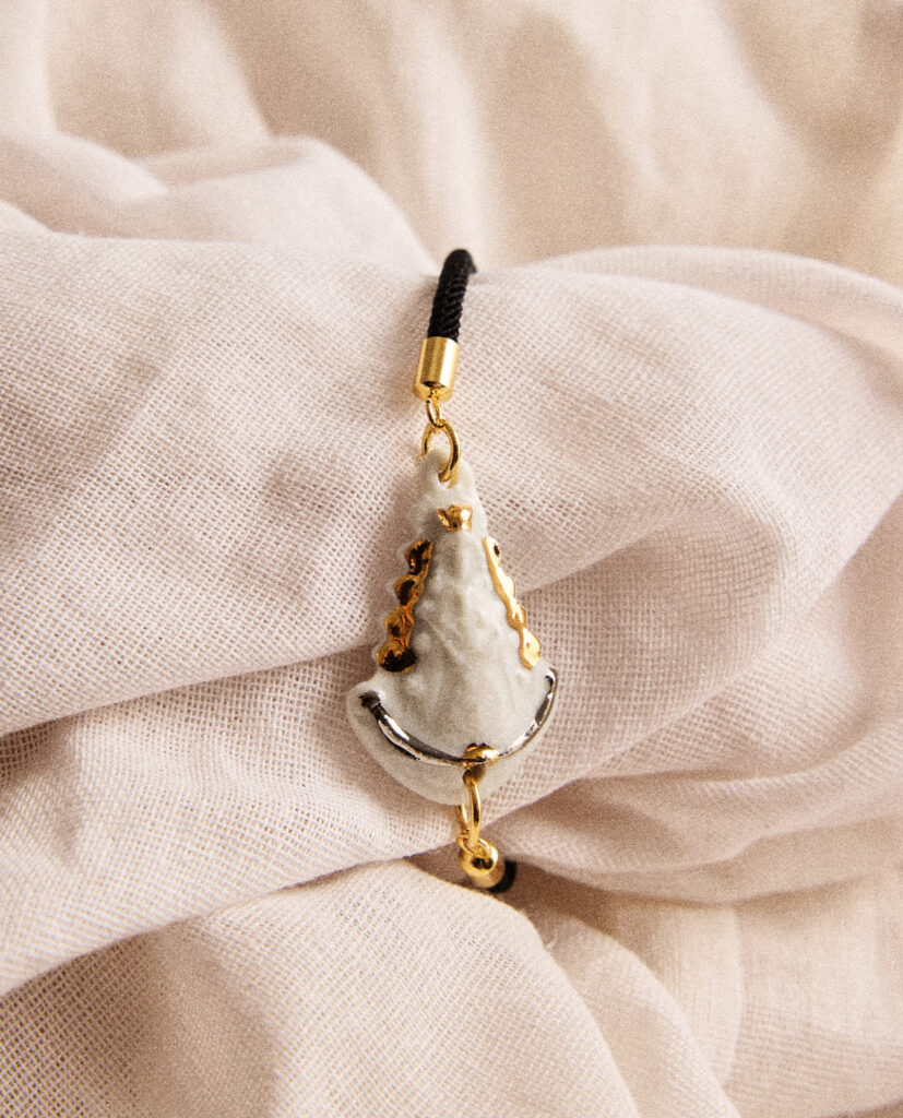 REGINA CAELI (Reina del cielo).
Pulsera medalla  Virgen del Rocío, modelada y pintada a mano, realizada en porcelana, cocida a 1230 grados y lustrada en oro y plata.Cordón ajustable con acabados de acero dorado.Disponible en dos tonos de cordón: marrón o negro.Medidas de la medalla: 3,6 x 2,5 cm.&nbsp;
Piezas únicas de cerámica realizadas mediante un proceso artesanal
En La Polaca, cada creación nace de un cuidadoso proceso artesanal. Trabajamos la porcelana, gres y arcillas a mano, modelando, esmaltando, lustrando y dando forma a cada detalle con dedicación y sensibilidad. Cada pieza evoluciona de manera natural en el taller, siguiendo el ritmo del oficio cerámico.
El resultado es siempre una pieza única, con matices, texturas y pequeñas variaciones que le otorgan personalidad propia.