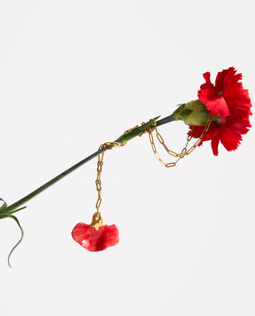 CLAVEL.
Collar cadena eslabones acero. Pieza cerámica modelada a mano, pigmentada en rojo y lustrada en oro.Medida pieza cerámica:  4 x 4 cm..PIEZA ÚNICA. El modelado a mano hace que sea imposible repetir un pétalo igual al otro. Estas piezas  son especiales por su unicidad.Medida pieza de porcelana:  6x3 cm (medidas aproximadas).
Piezas únicas de cerámica realizadas mediante un proceso artesanal
En La Polaca, cada creación nace de un cuidadoso proceso artesanal. Trabajamos la porcelana, gres y arcillas a mano, modelando, esmaltando, lustrando y dando forma a cada detalle con dedicación y sensibilidad. Cada pieza evoluciona de manera natural en el taller, siguiendo el ritmo del oficio cerámico.
El resultado es siempre una pieza única, con matices, texturas y pequeñas variaciones que le otorgan personalidad propia.
&nbsp;