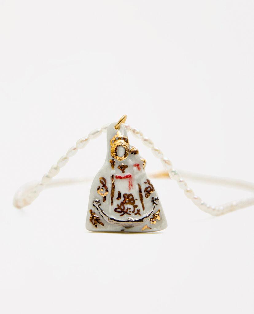 REGINA CAELI (Reina del cielo).
Collar medalla Virgen de la Fuensanta, modelada y pintada a mano, realizada en PORCELANA, cocida a 1230 grados y lustrada en ORO.Collar de perla natural forma orgánica 5mm..Medidas de la medalla: 3,7 x 2,7 cm.Medidas longitud collar: 46cm.&nbsp;
Piezas únicas de cerámica realizadas mediante un proceso artesanal
En La Polaca, cada creación nace de un cuidadoso proceso artesanal. Trabajamos la porcelana, gres y arcillas a mano, modelando, esmaltando, lustrando y dando forma a cada detalle con dedicación y sensibilidad. Cada pieza evoluciona de manera natural en el taller, siguiendo el ritmo del oficio cerámico.
El resultado es siempre una pieza única, con matices, texturas y pequeñas variaciones que le otorgan personalidad propia.